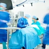Équipe chirurgicale autour d'une table d'opérations en bloc opératoire